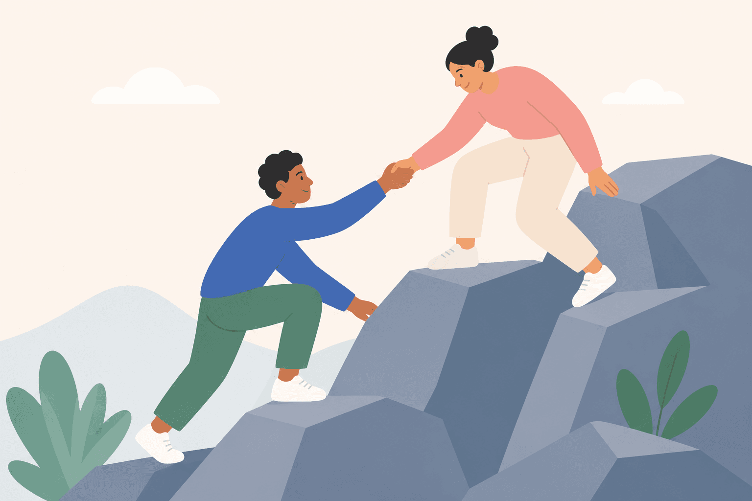 Two people helping each other climb a rocky outcrop